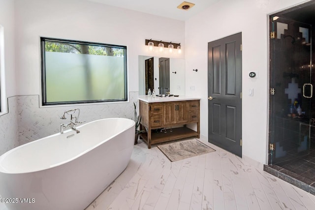 670 Winslow Rd, Edwards, CO 81632 - bathroom with vanity, a freestanding tub, a shower stall, and marble look tiles