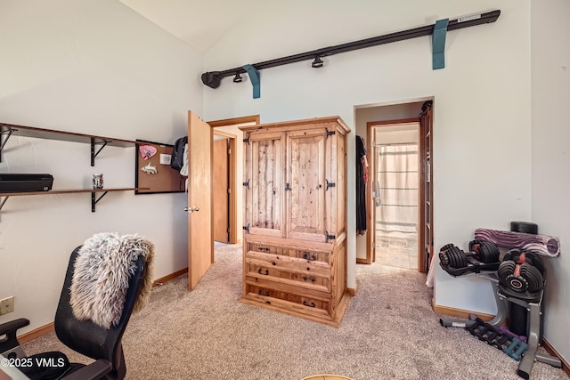 home office with light colored carpet and vaulted ceiling