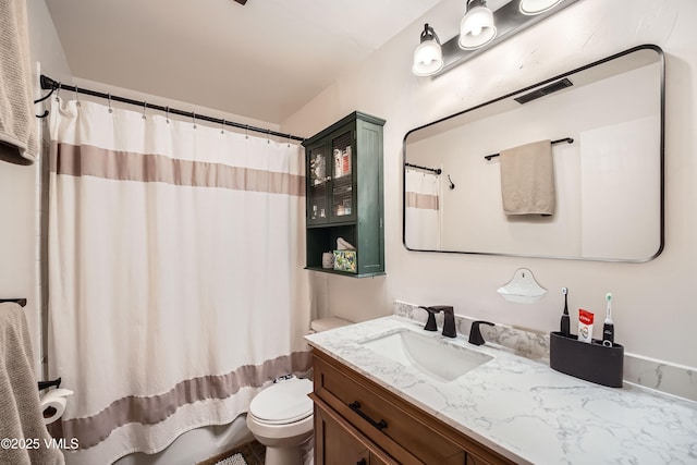 bathroom featuring vanity, a shower with shower curtain, and toilet