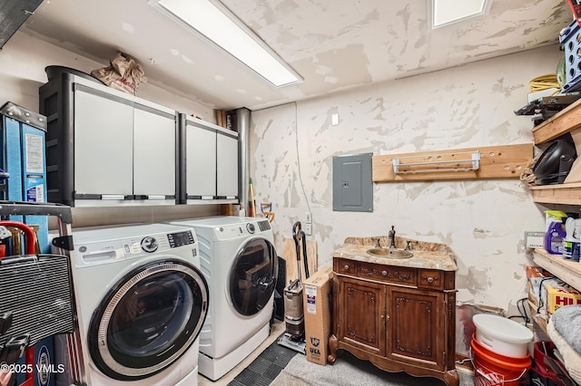 clothes washing area featuring independent washer and dryer, sink, electric panel, and cabinets