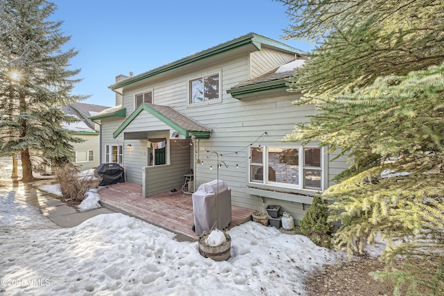 snow covered property featuring a deck