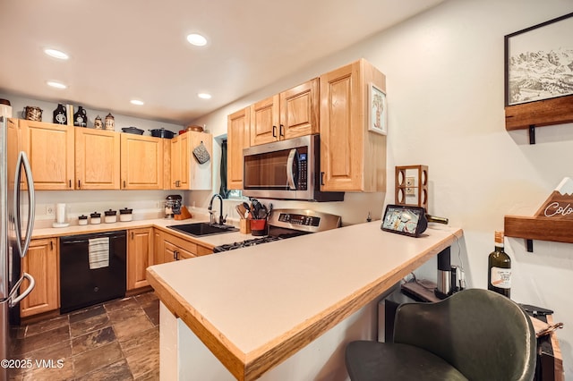 kitchen with appliances with stainless steel finishes, light brown cabinetry, kitchen peninsula, and sink