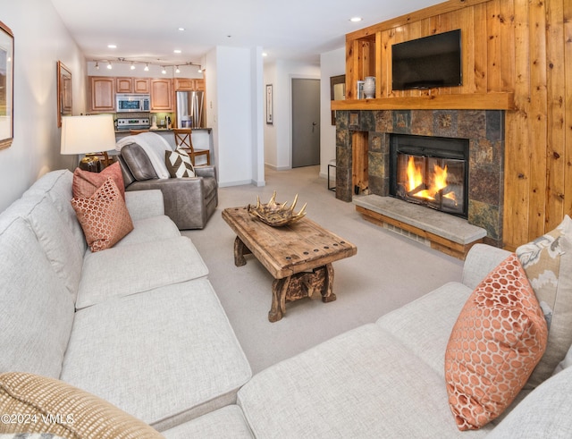 carpeted living room featuring rail lighting and a fireplace