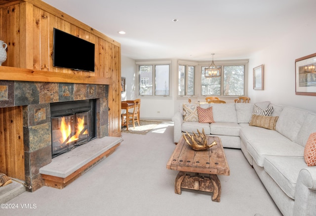 carpeted living room featuring a tiled fireplace and a healthy amount of sunlight