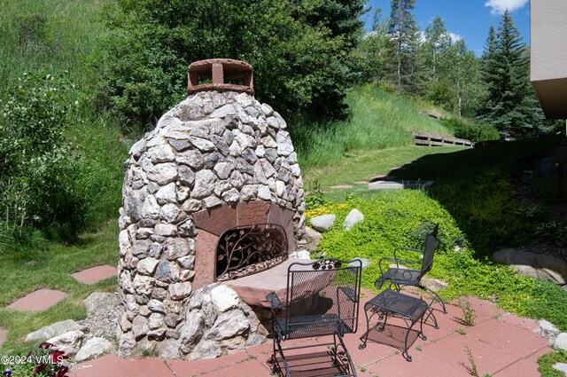 311 Offerson Rd Unit 329, Beaver Creek, CO 81620 - view of patio featuring an outdoor stone fireplace