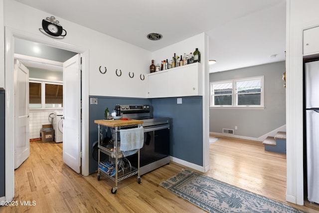 618 W Chestnut St, Leadville, CO 80461 - kitchen with electric range, light wood-style floors, white cabinetry, and baseboards