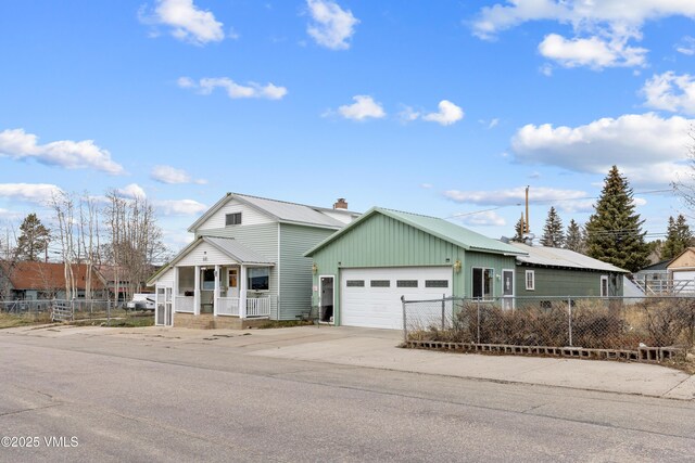 618 W Chestnut St, Leadville, CO 80461 - view of front facade with fence, an attached garage, covered porch, and concrete driveway