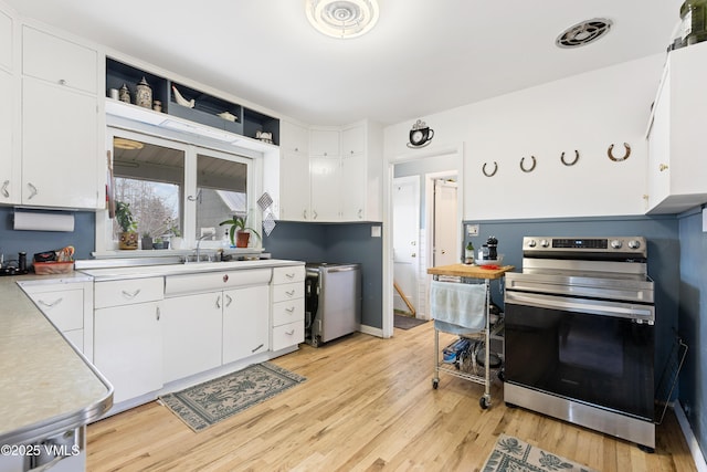 618 W Chestnut St, Leadville, CO 80461 - kitchen featuring stainless steel electric range, light countertops, white cabinets, light wood-type flooring, and a sink