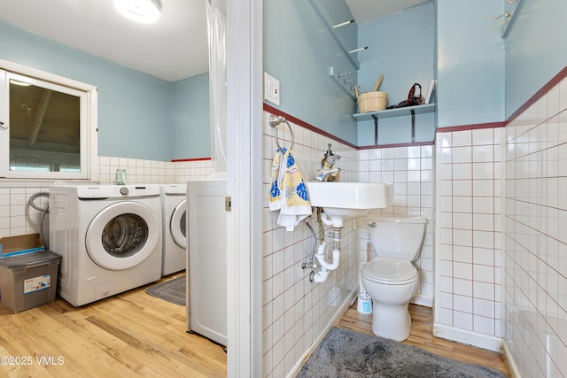 618 W Chestnut St, Leadville, CO 80461 - bathroom featuring tile walls, washing machine and clothes dryer, wood finished floors, toilet, and wainscoting