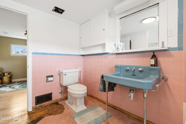 618 W Chestnut St, Leadville, CO 80461 - half bath featuring tile walls, toilet, a sink, and wainscoting