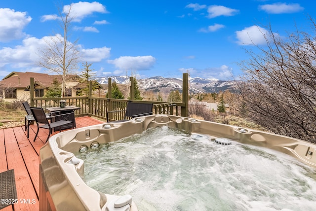 wooden deck with a hot tub and a mountain view
