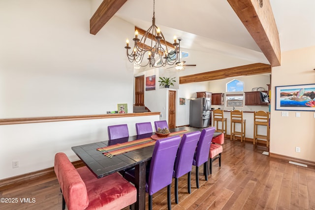 dining area with baseboards, vaulted ceiling with beams, ceiling fan with notable chandelier, and wood finished floors