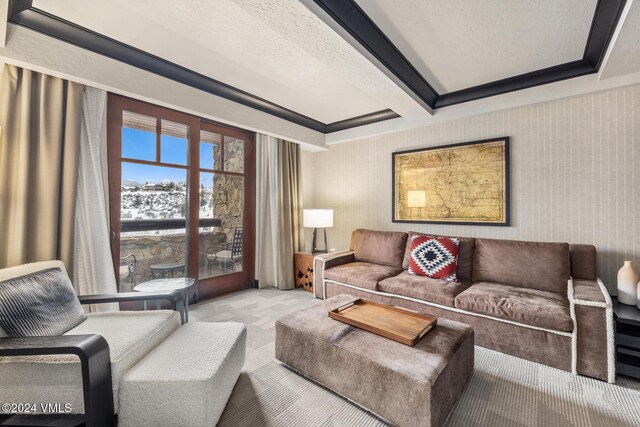 living room featuring light carpet, beam ceiling, and a textured ceiling