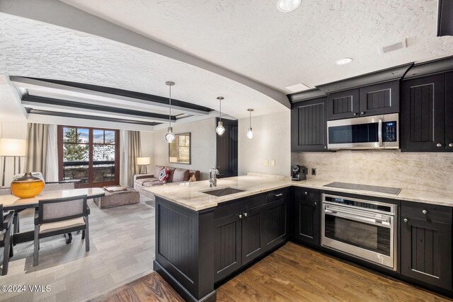 kitchen featuring sink, decorative light fixtures, appliances with stainless steel finishes, dark hardwood / wood-style floors, and kitchen peninsula