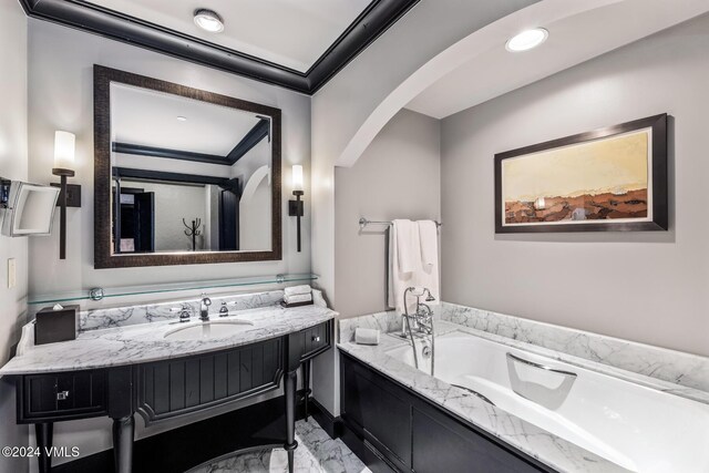 bathroom with vanity, a tub, and crown molding