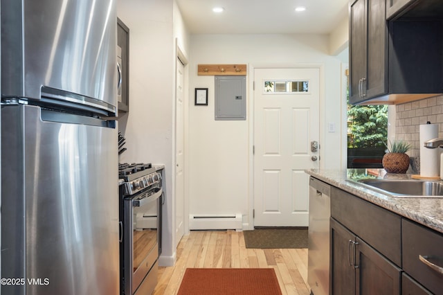 909 Red Sandstone Rd Unit B2, Vail, CO 81657 - kitchen with stainless steel appliances, a baseboard radiator, electric panel, light wood-style floors, and dark brown cabinetry