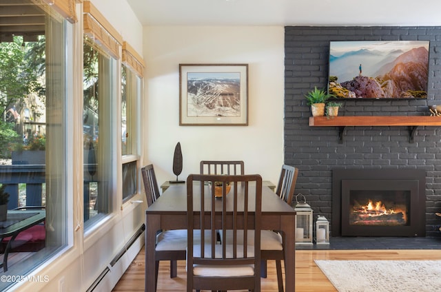 909 Red Sandstone Rd Unit B2, Vail, CO 81657 - dining room featuring wood finished floors, a fireplace, and baseboard heating