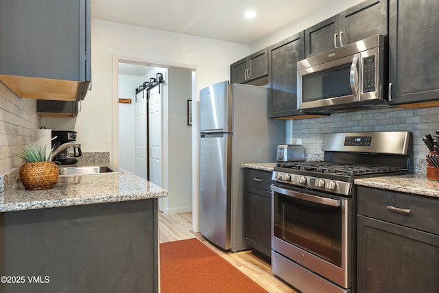 909 Red Sandstone Rd Unit B2, Vail, CO 81657 - kitchen featuring appliances with stainless steel finishes, a sink, light wood-style floors, and tasteful backsplash
