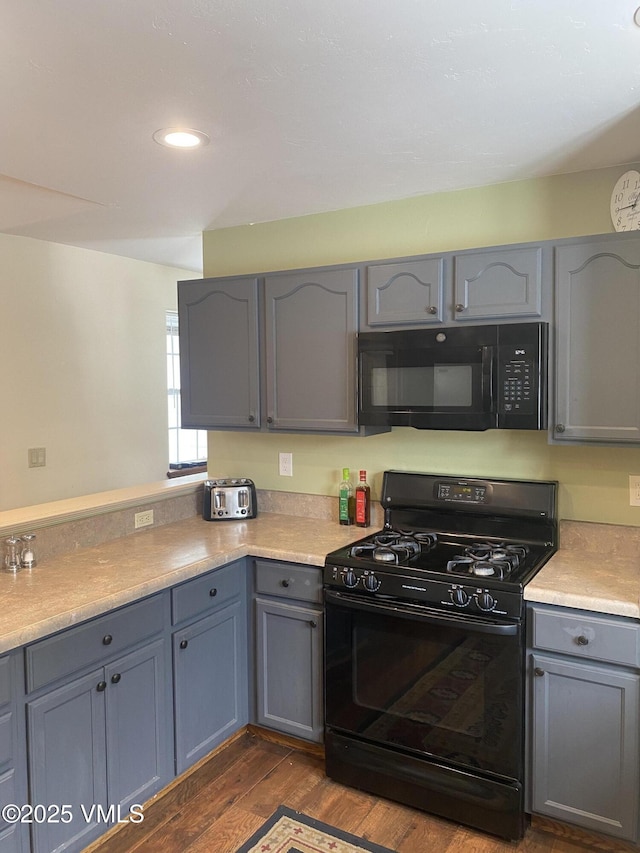 kitchen featuring dark hardwood / wood-style flooring, gray cabinets, and black appliances