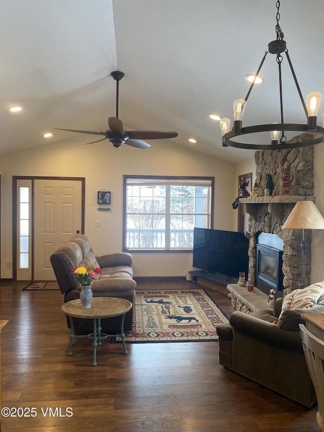 living room with a stone fireplace, dark wood-type flooring, ceiling fan, and vaulted ceiling