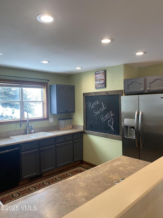 kitchen featuring stainless steel fridge, black dishwasher, and sink