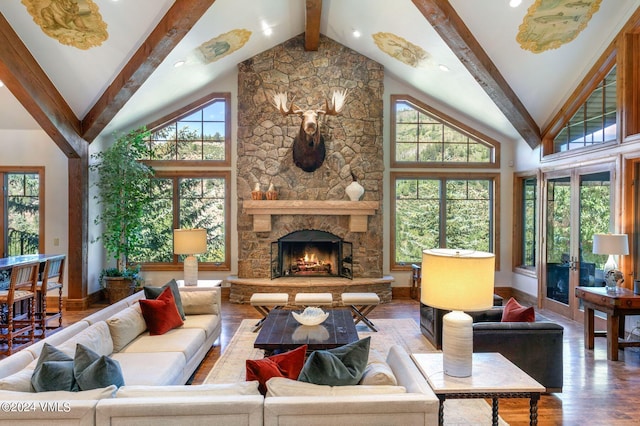 living room featuring wood-type flooring, a stone fireplace, high vaulted ceiling, and beam ceiling