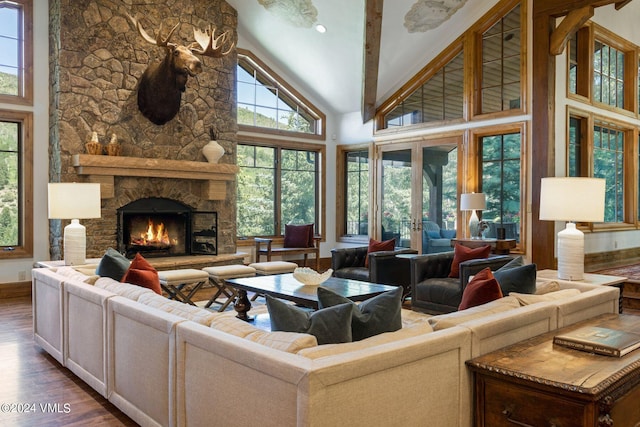 living room featuring french doors, a stone fireplace, dark hardwood / wood-style flooring, and high vaulted ceiling