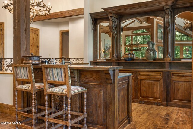 bar with a healthy amount of sunlight and dark hardwood / wood-style floors