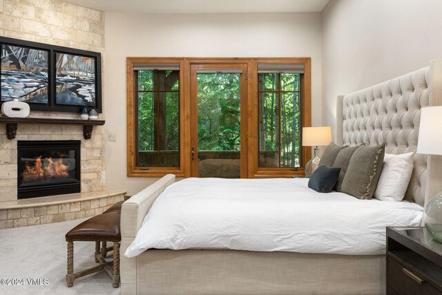 carpeted bedroom featuring a fireplace