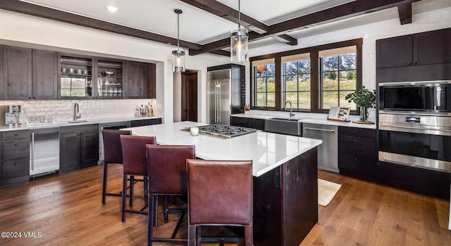 367 Hunters View Ln, Eagle, CO 81631 - kitchen with appliances with stainless steel finishes, a sink, backsplash, light countertops, and beamed ceiling