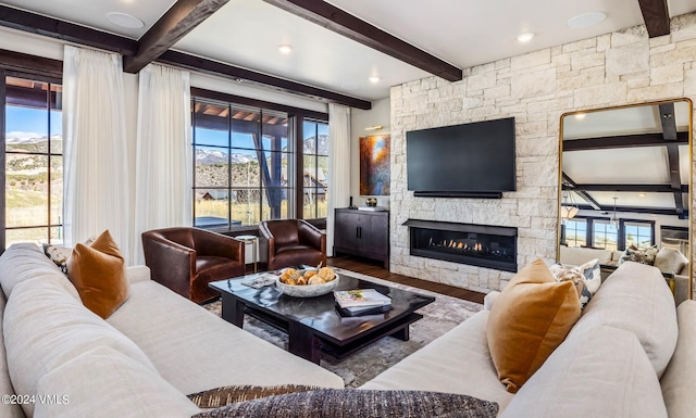 367 Hunters View Ln, Eagle, CO 81631 - living area with beamed ceiling, wood finished floors, a stone fireplace, and healthy amount of natural light