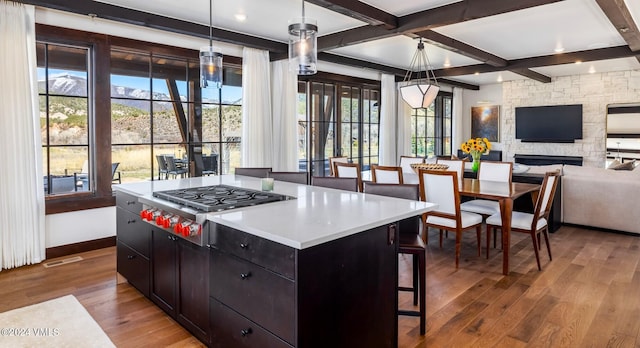 367 Hunters View Ln, Eagle, CO 81631 - kitchen featuring stainless steel gas stovetop, wood finished floors, plenty of natural light, open floor plan, and beamed ceiling