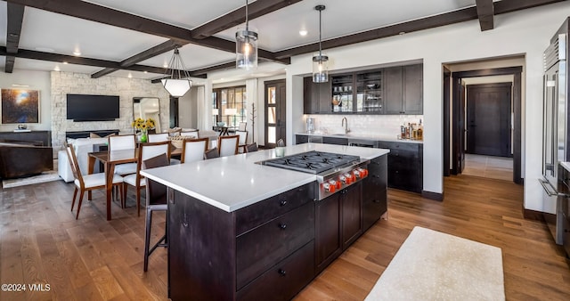 367 Hunters View Ln, Eagle, CO 81631 - kitchen featuring stainless steel gas cooktop, wood finished floors, a kitchen bar, light countertops, and beamed ceiling