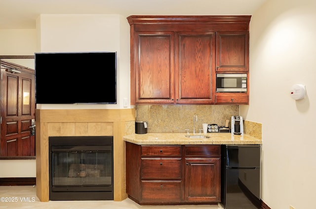 26 Avondale Ln Unit 502-H, Beaver Creek, CO 81620 - kitchen with freestanding refrigerator, stainless steel microwave, backsplash, light stone countertops, and dark brown cabinets