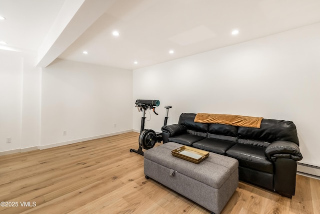 living area featuring recessed lighting, light wood-type flooring, baseboards, and a baseboard heating unit