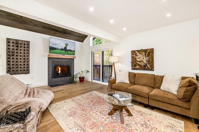 living area with recessed lighting, wood finished floors, a fireplace with flush hearth, and baseboards