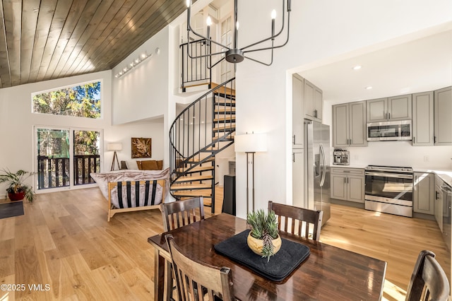 dining space with high vaulted ceiling, stairway, light wood finished floors, wood ceiling, and recessed lighting