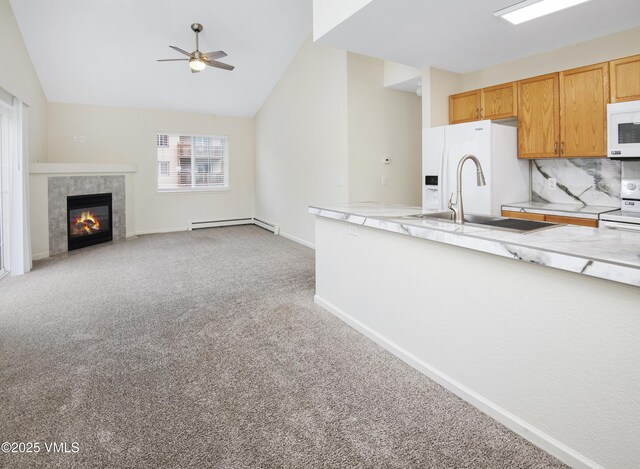 1404 Crazy Horse Cir Unit 1404, Edwards, CO 81632 - kitchen with baseboard heating, a ceiling fan, light colored carpet, white appliances, and vaulted ceiling