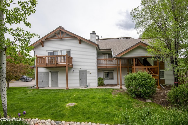 1404 Crazy Horse Cir Unit 1404, Edwards, CO 81632 - rear view of house with a yard, a chimney, a shingled roof, and a balcony