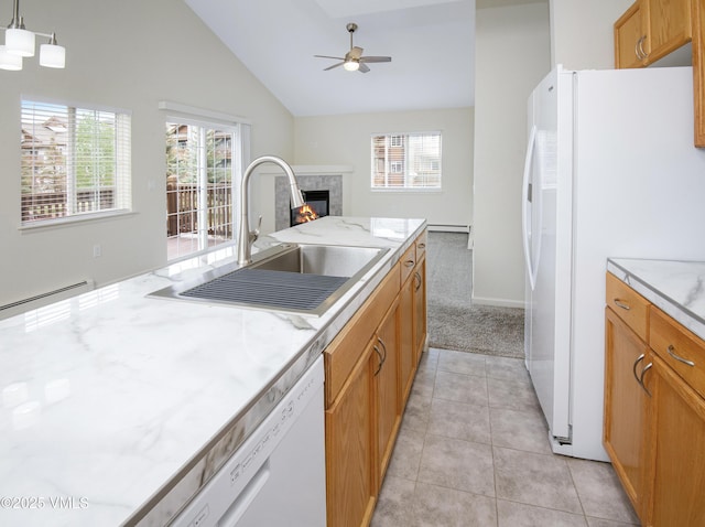 1404 Crazy Horse Cir Unit 1404, Edwards, CO 81632 - kitchen featuring a sink, white appliances, plenty of natural light, vaulted ceiling, and a warm lit fireplace