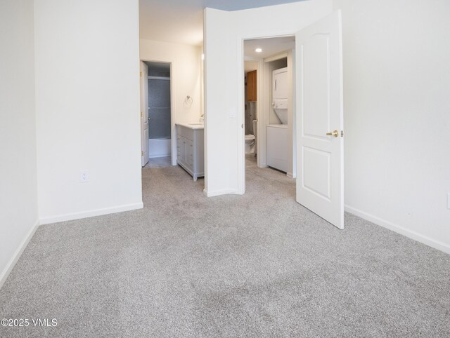 1404 Crazy Horse Cir Unit 1404, Edwards, CO 81632 - unfurnished bedroom featuring estacked washer and dryer, carpet, and baseboards