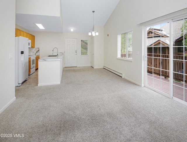 1404 Crazy Horse Cir Unit 1404, Edwards, CO 81632 - kitchen featuring baseboard heating, white appliances, light colored carpet, light countertops, and lofted ceiling
