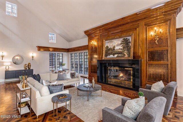 living area featuring a glass covered fireplace and high vaulted ceiling