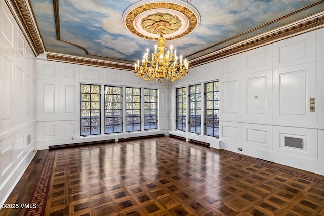 unfurnished dining area featuring a decorative wall, a notable chandelier, and ornamental molding