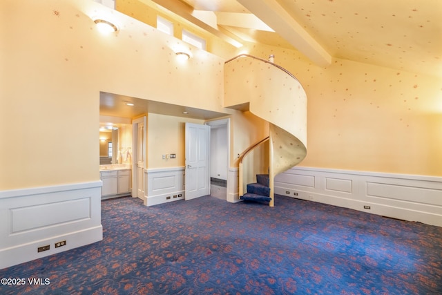 additional living space featuring stairway, wainscoting, lofted ceiling with beams, and carpet floors