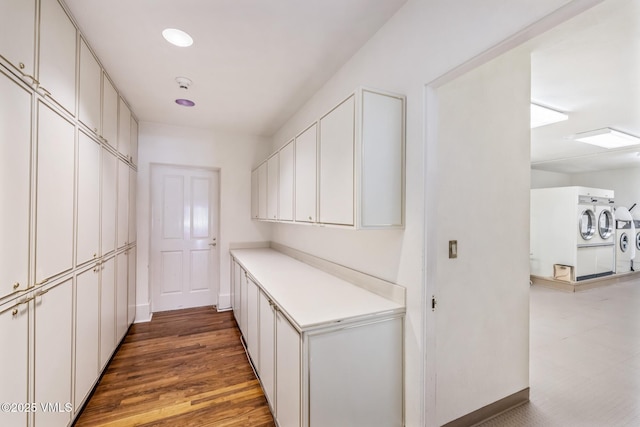 interior space featuring washing machine and dryer, light countertops, recessed lighting, wood finished floors, and white cabinets