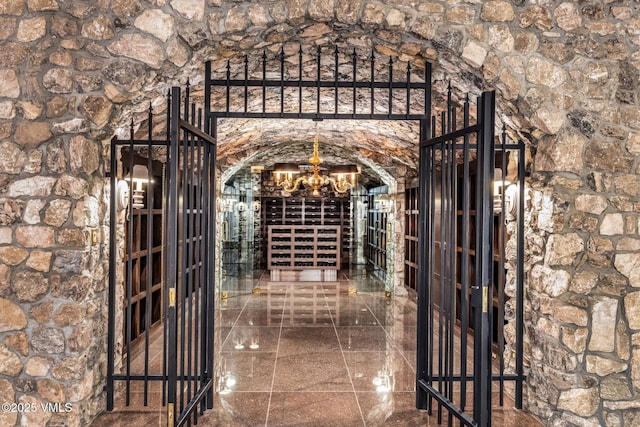 wine cellar with a chandelier and granite finish floor