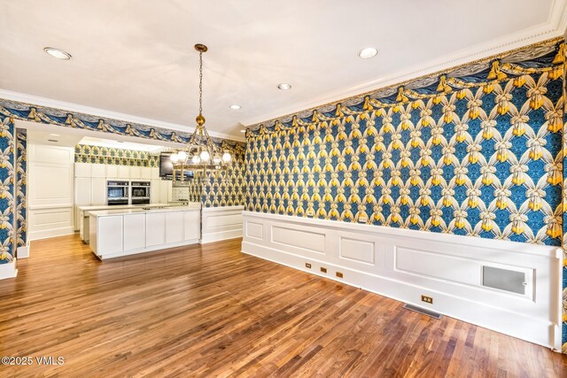 unfurnished dining area with recessed lighting, visible vents, light wood-style flooring, and crown molding