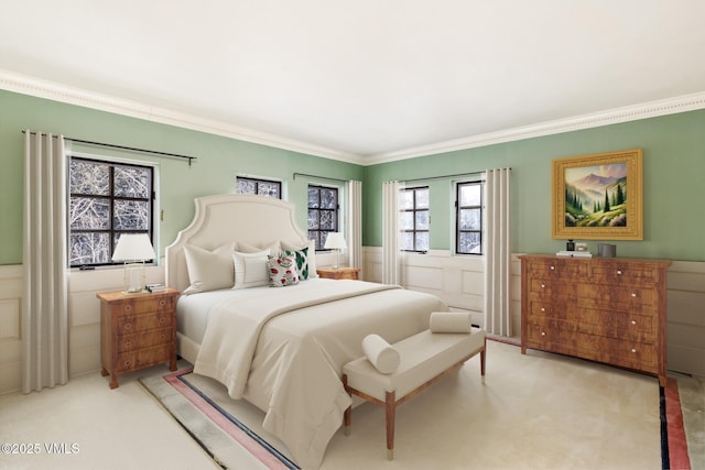 carpeted bedroom featuring ornamental molding and wainscoting