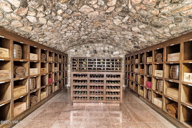 wine room featuring lofted ceiling and granite finish floor